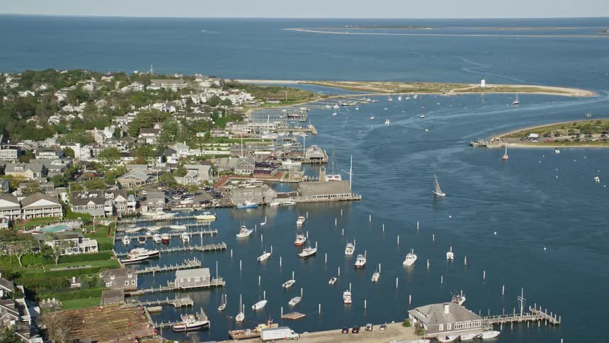 Aerial view of boats on a marina next to a small town