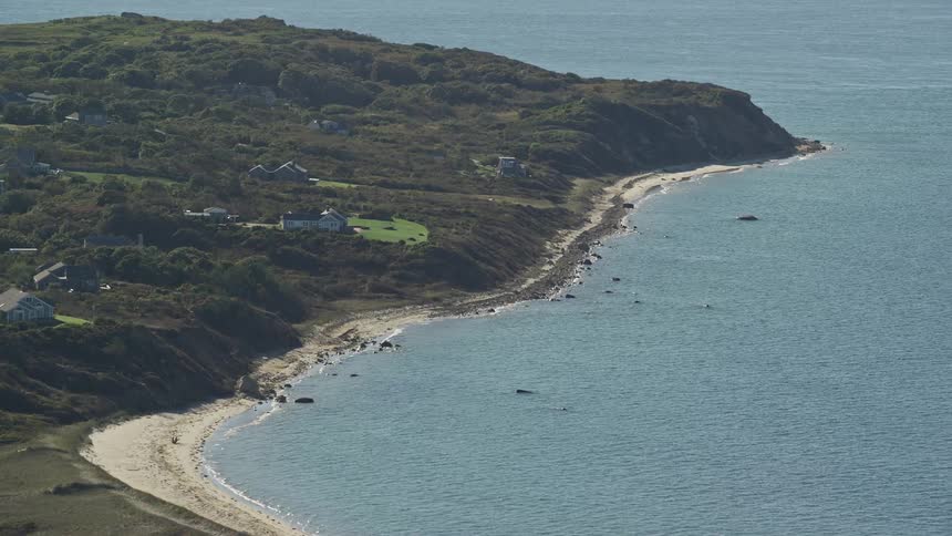 An aerial view of a land facing the sea with a sandy beach