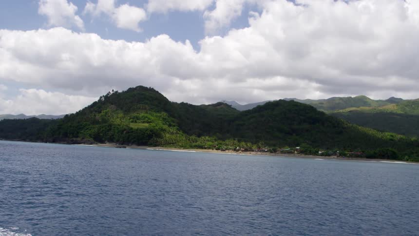 Hills covered with green line the shore ahead