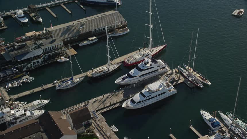 A white yacht parked at the pier next to several boats