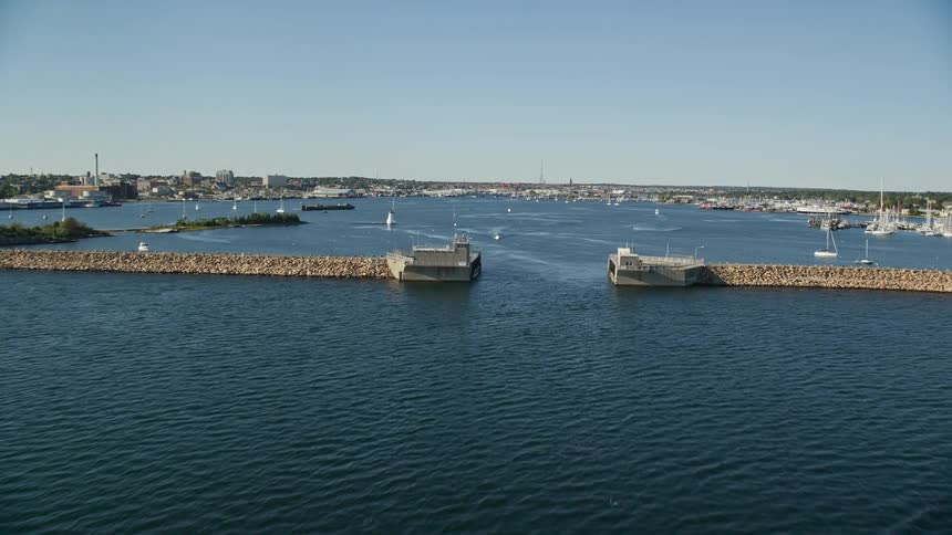 Close to the bay boats are docked with a breakwaters barricade