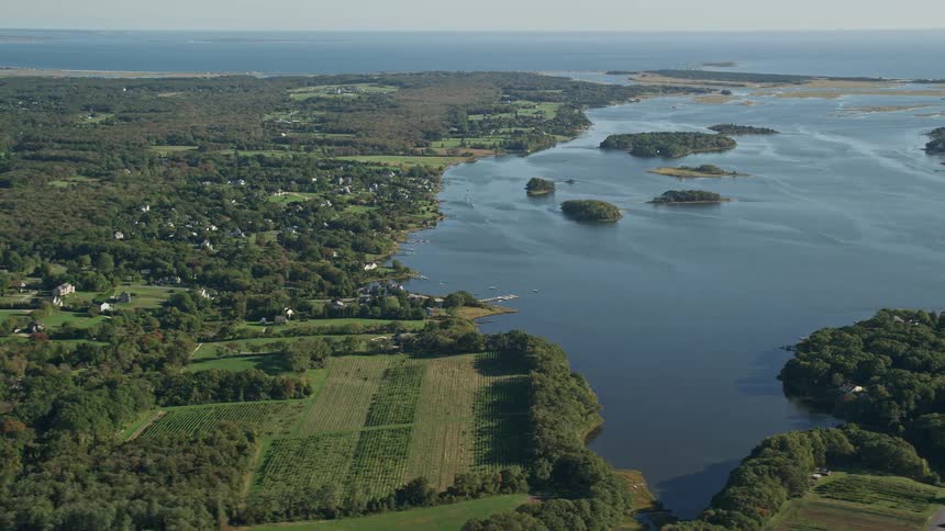 Aerial panorama of a view of fields houses and vast natural scenery by the sea