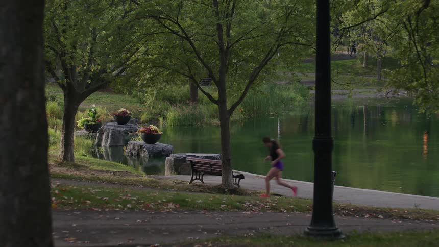 Woman running in a park with a lake
