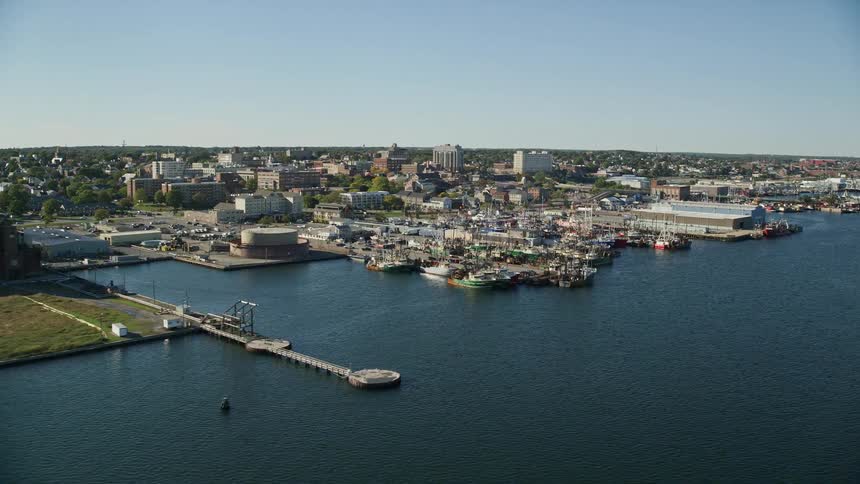 Aerial view of boats and ships on a pier next to a small city