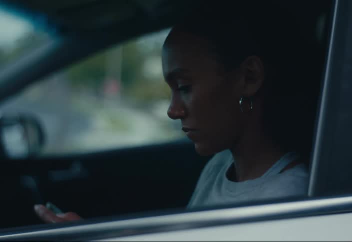 Woman sitting in the front seat of the car using her cell phone