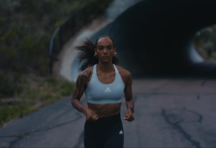 Woman runs on a road through a tunnel