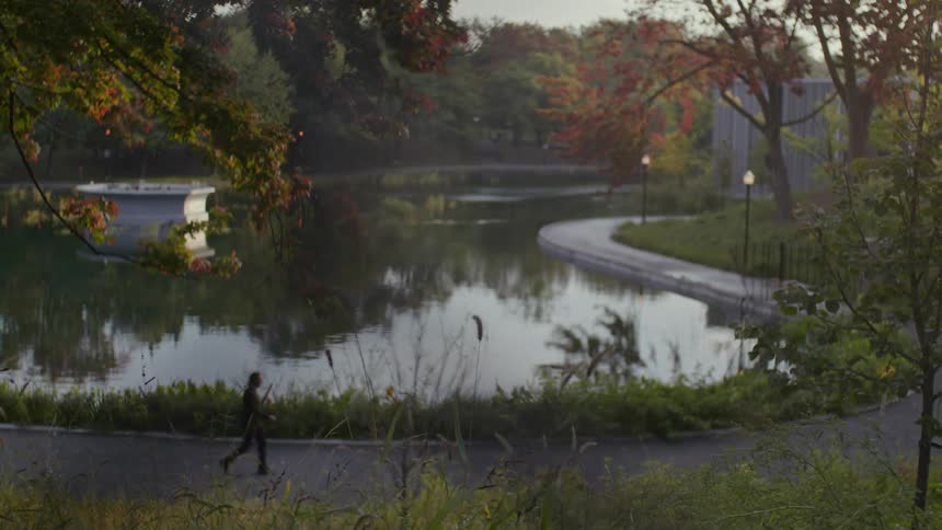Several people running and walking on a path in front of a lake