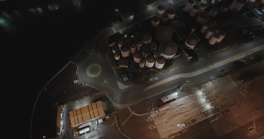 Aerial of silos in different sizes at night