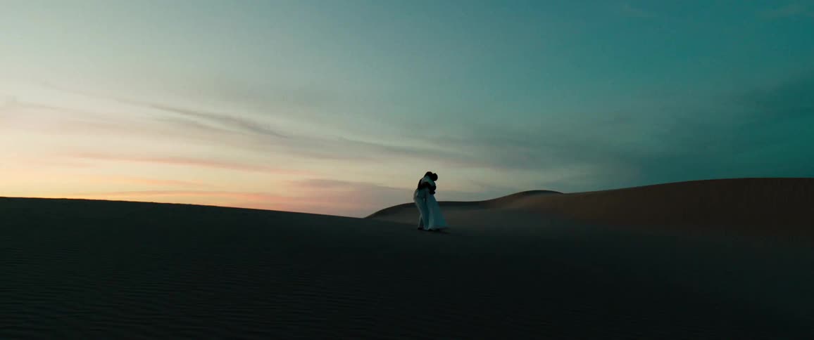Man and woman running hugging and kneeling together at dawn in a natural outdoor setting