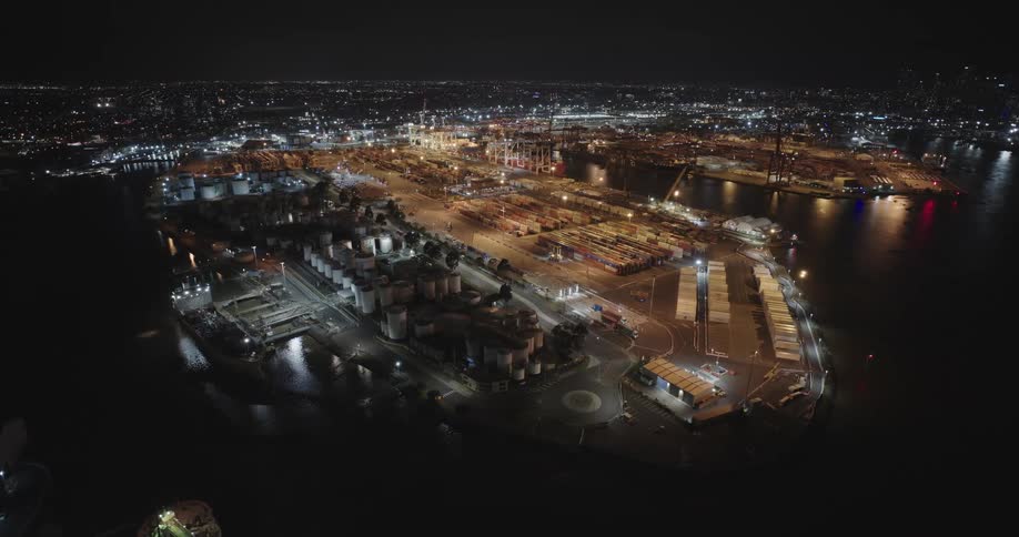 Aerial of containers in a factory located at waterfront at night