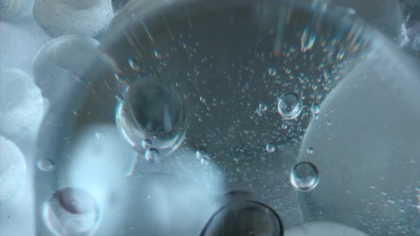 A surface of a liquid with several bubbles and bubbling places