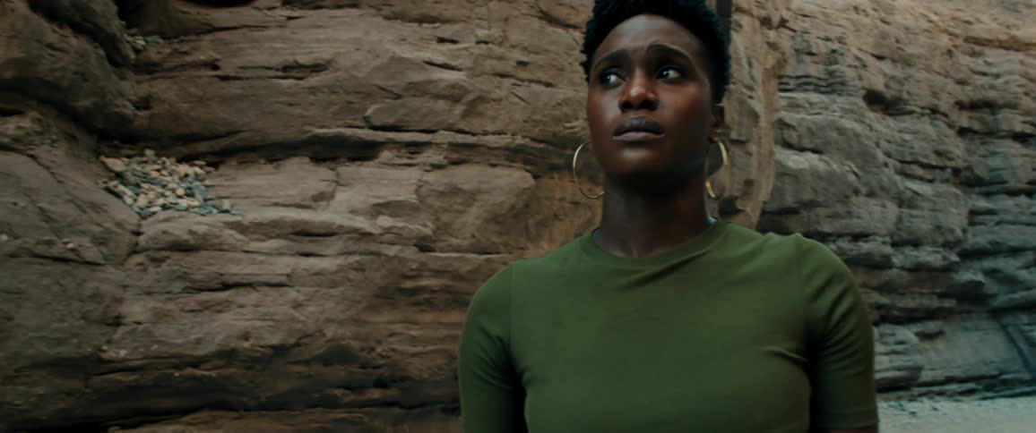 A woman hiking past a canyon looks scared