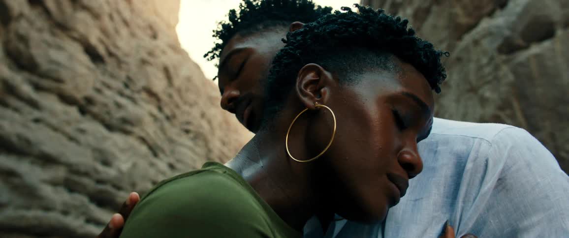 Man and woman hugging in a natural environment with rocks during the day