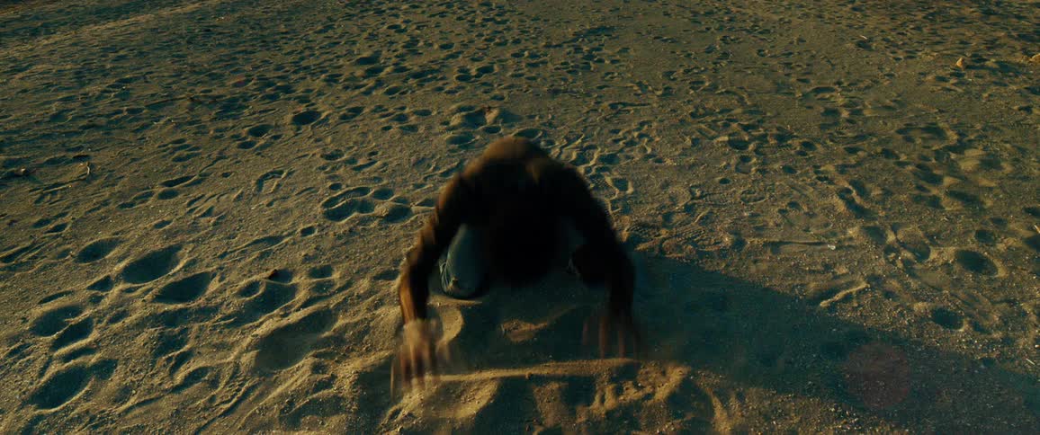 A man crouched in the sand is nervous and throwing sand aside with his hand