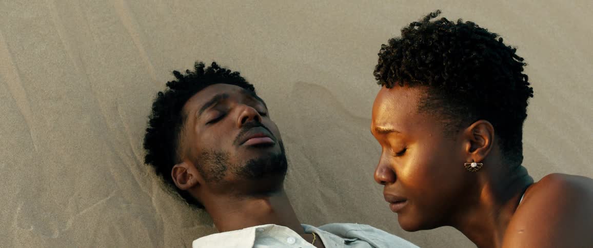 Woman cries while lying against a motionless man lying on the ground