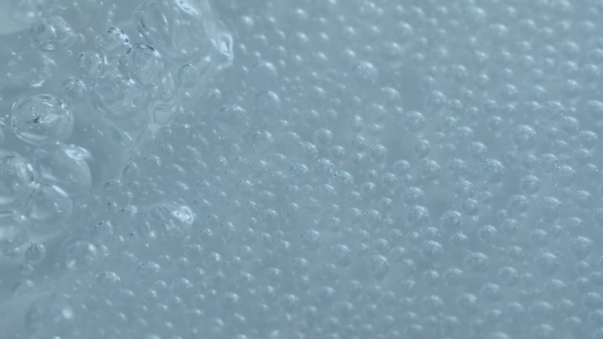 Soapy bubbles flow over surface of water