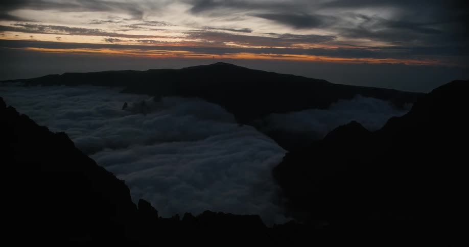 Timelapse of Piton des neiges panorama above the clouds with the sky darkening