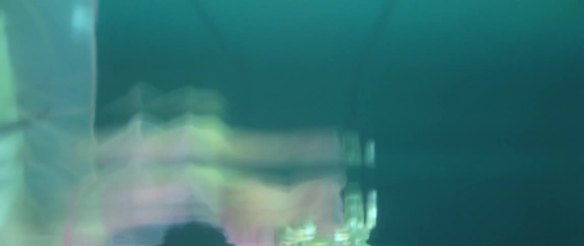 An arm and hand covered in pink chiffon floats in water
