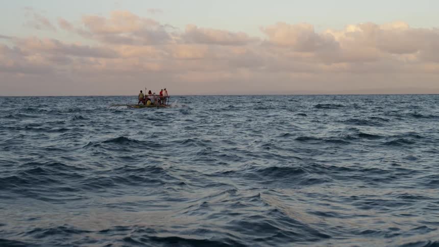 Several people on a small boat in the middle of the ocean