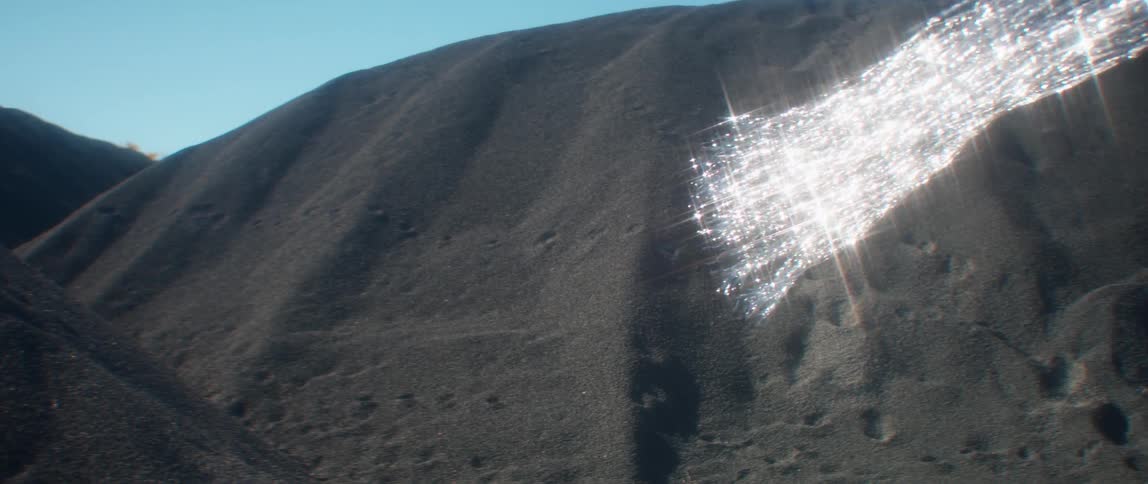 Silver tinsel waving in the air near sand hills