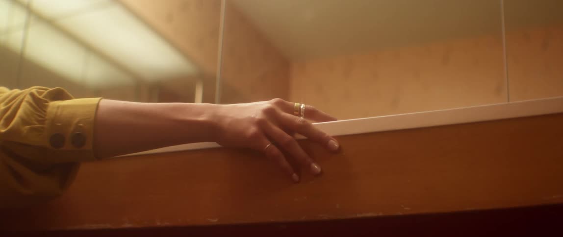 A womans arm resting on a piece of wood in a mirrored room