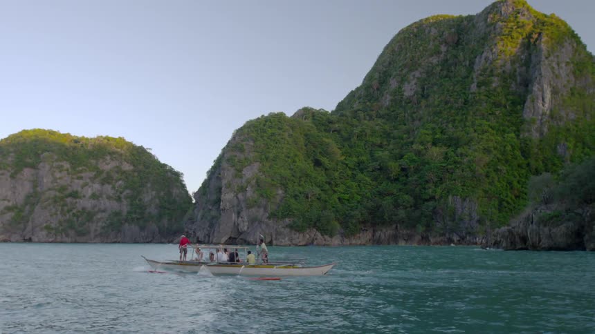 People are traveling on a boat near a mountain