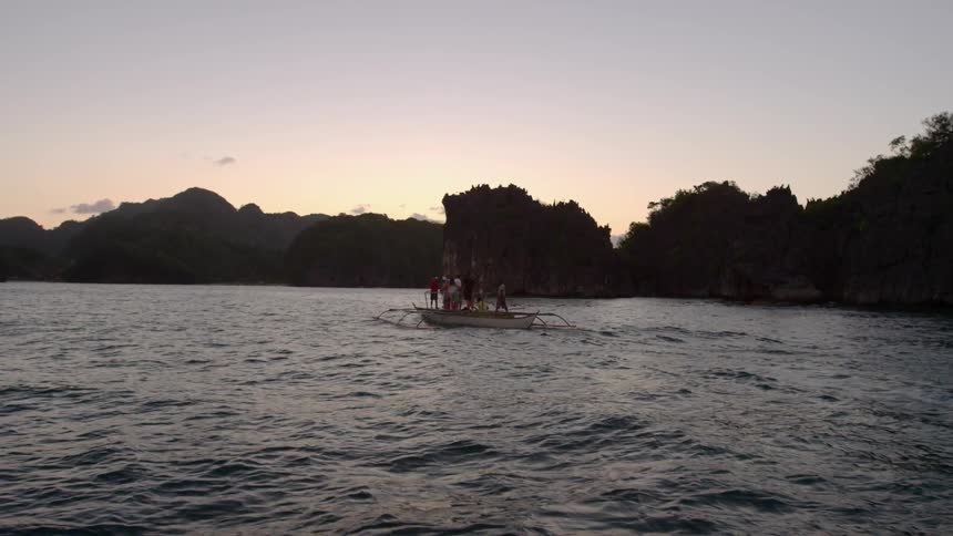 People stand in a boat out in the water