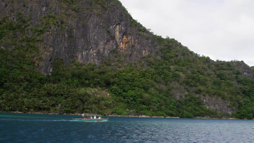 A boat glides past the shore