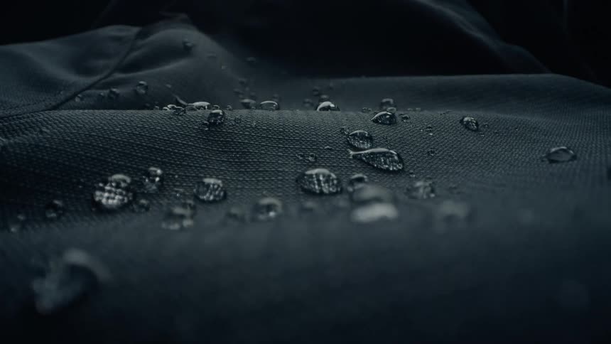 Water drops vibrating on waterproof cloth flow across the surface of the fabric