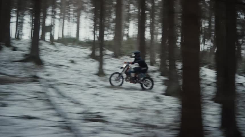 A motocross biker riding over a snowy environment