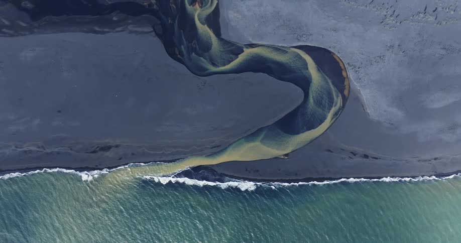 Aerial view of a blue and yellow river meeting the ocean
