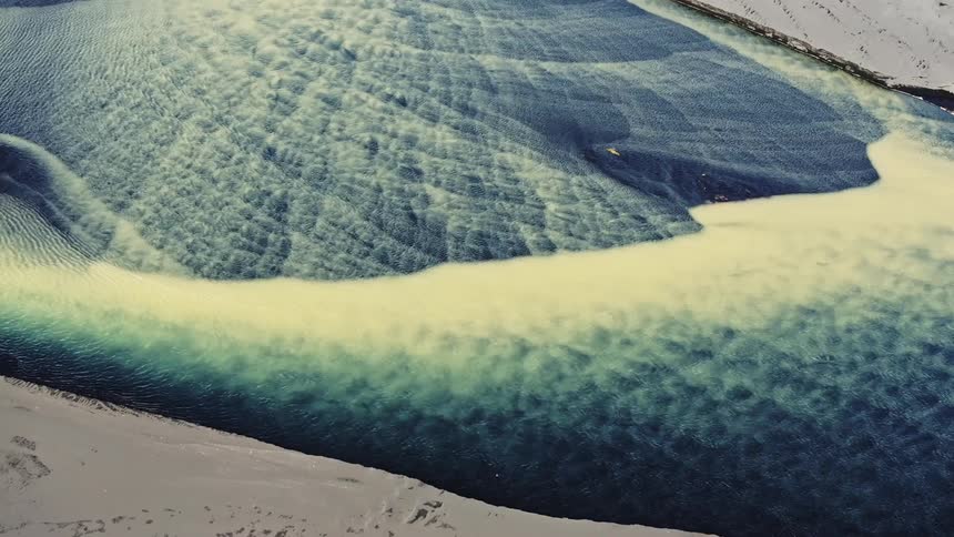 Aerial view of a river with blue and yellow water