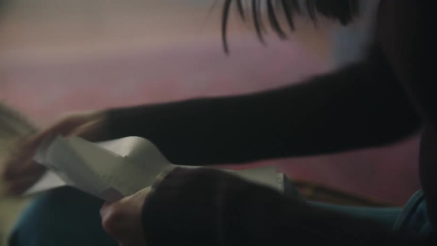 A woman sits down at a small table while she sorts through receipts