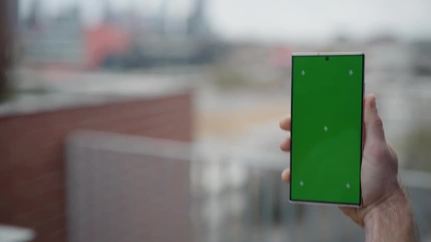 A person is walking while holding their cell phone up