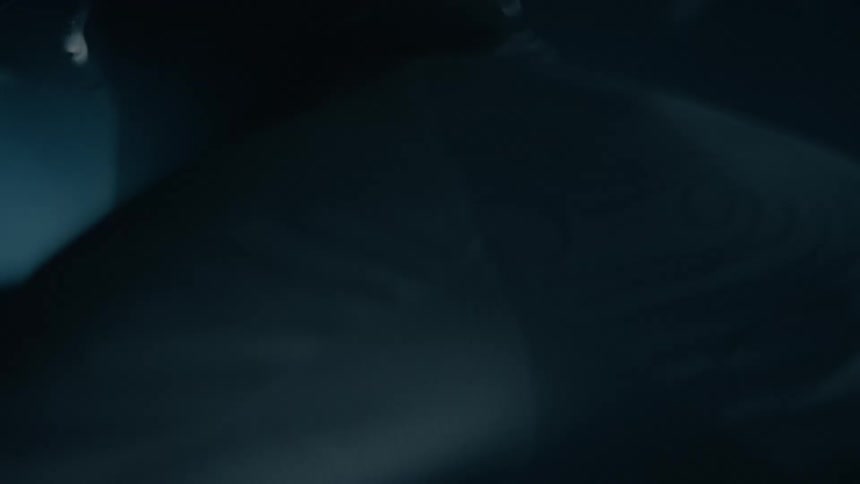 Man wearing a black crash helmet drives a motorcycle at night