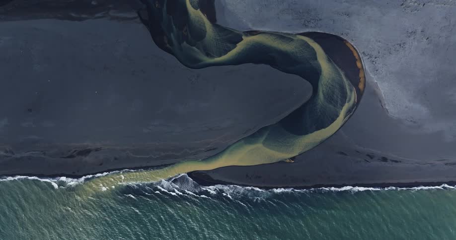 Aerial view of a blue and yellow river meeting the ocean