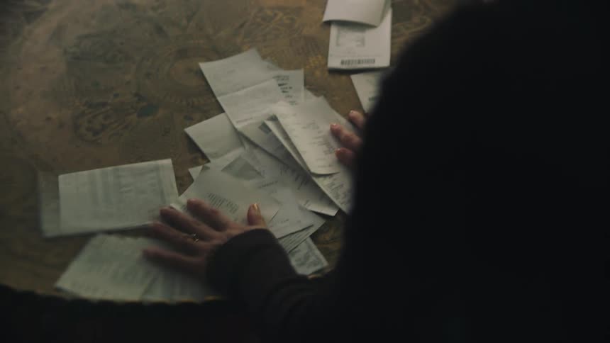 A person dropping bunch of receipt on a tray