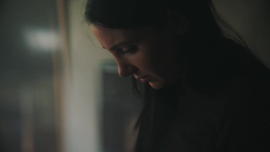 A woman with dark hair looks down while contemplating what she needs to do