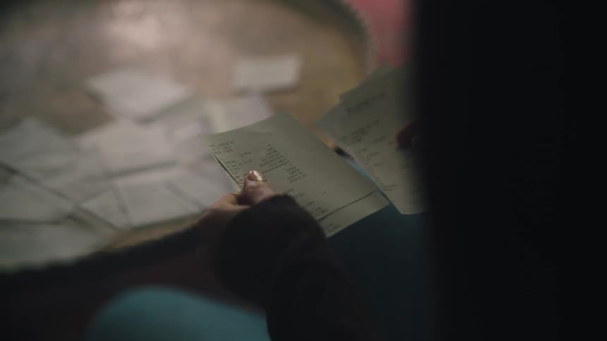 A person looking at shopping receipts