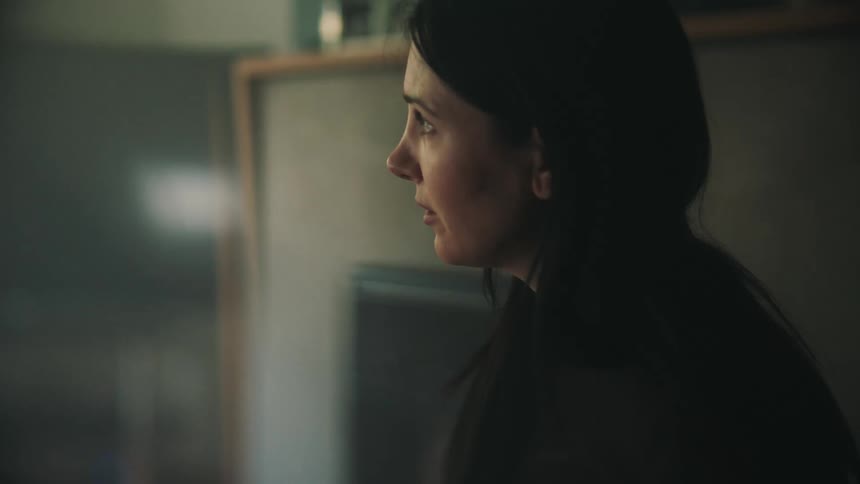 A brunette lady crying indoor while looking around