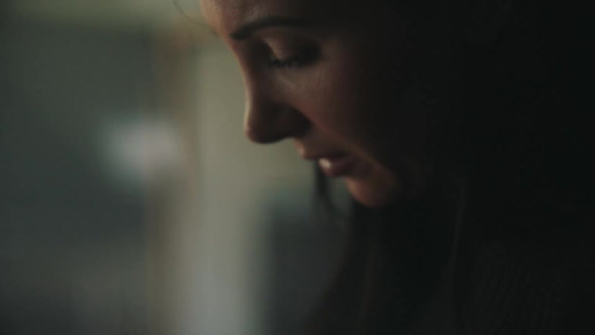 Face of a woman sitting indoors and crying