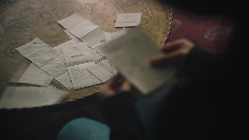 Woman reading receipts at home