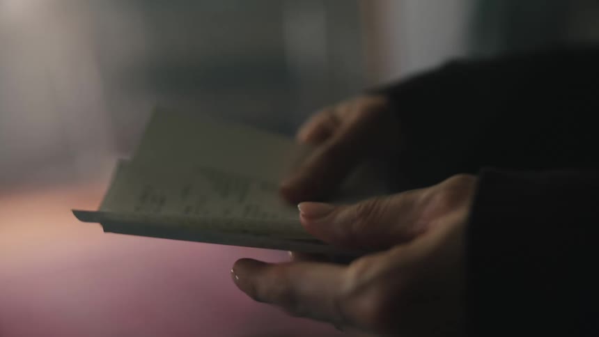 A woman is looking at receipts in her hands