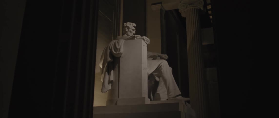 Abraham lincoln sculpture in a museum at night