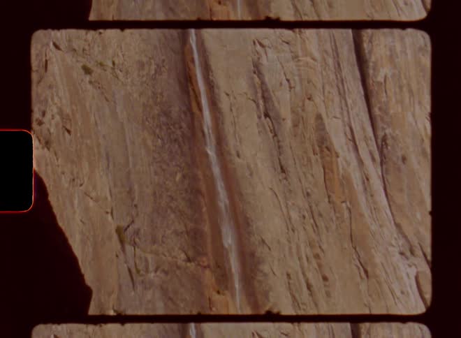 A narrow waterfall flows downward from a very great height