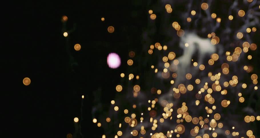 A stream of gold particles flowing across the darkness