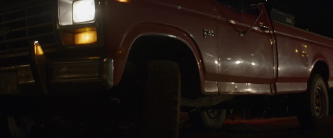 At night a red pick up truck pulls up and people with flashlights get our