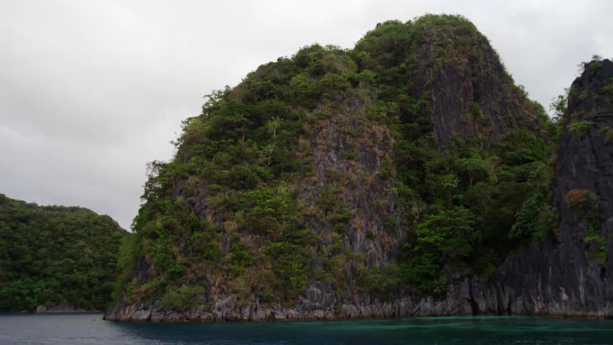 Mountains are covered with bushes and surrounded by water