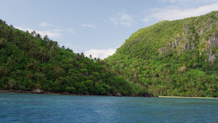 The shore is lined with hills covered with trees and grass