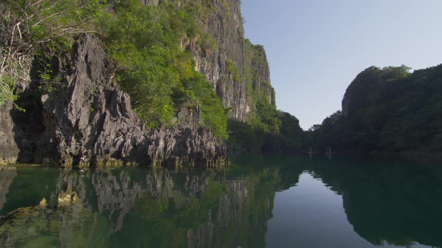 The water leads to a tall cliff ahead